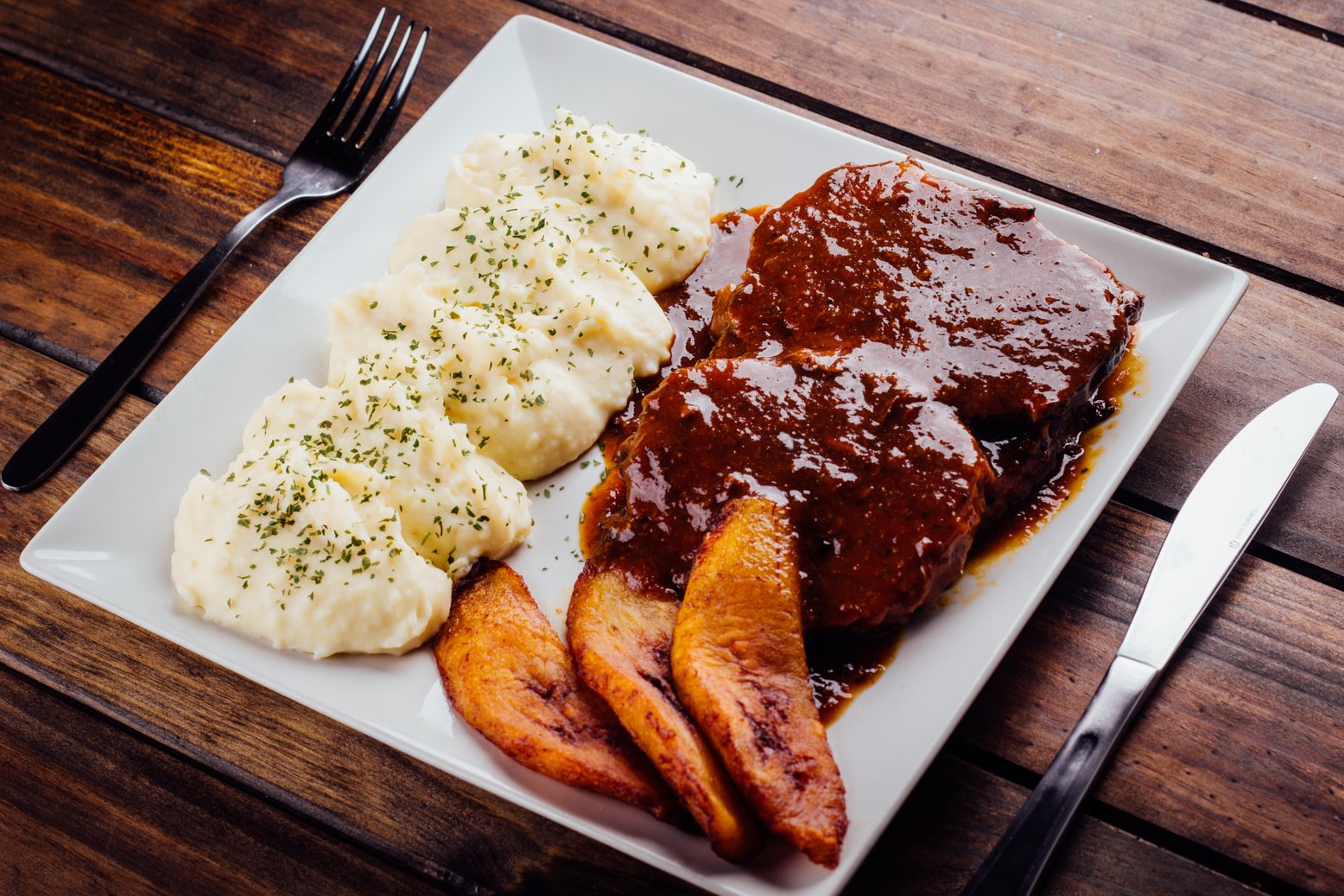 Asado negro with mashed potatoes and fried plantain